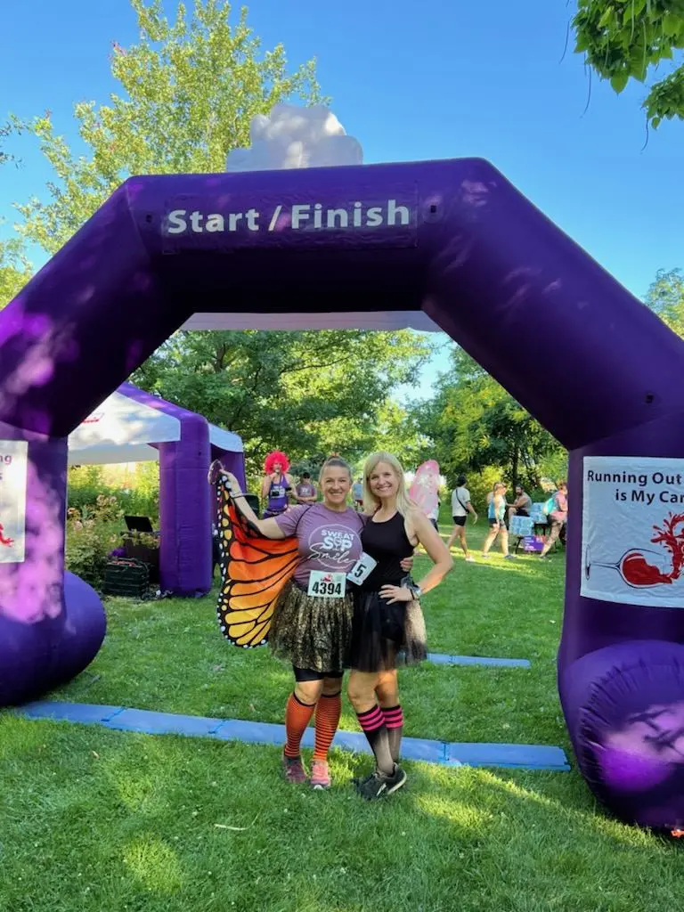 Friends in butterfly wings at a race start line