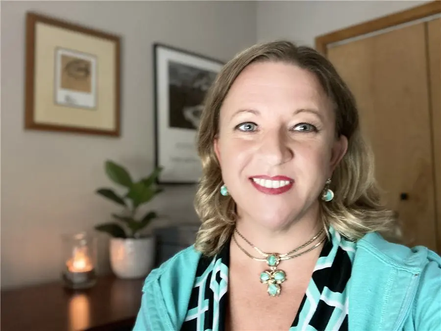 CarrieAnne Kowalczyk smiling in her office